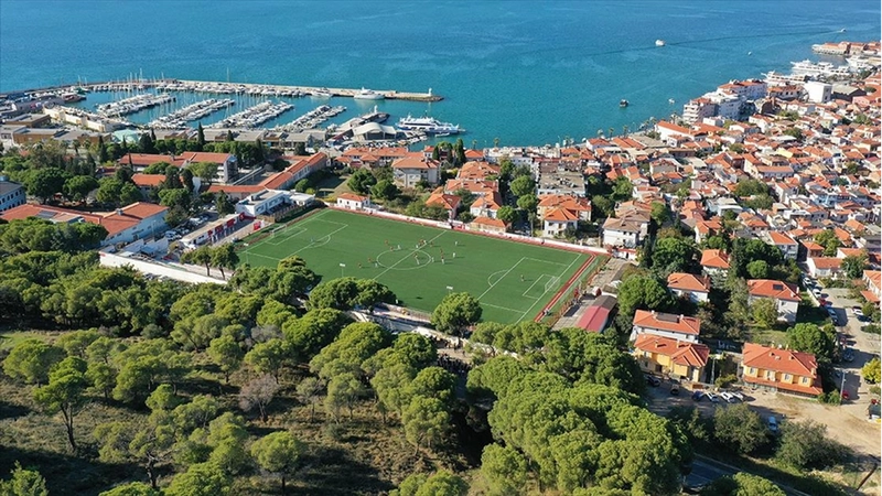 Ağaçların gölgesinde deniz manzaralı tribünde maç keyfi