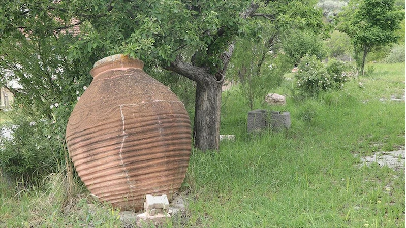 Köydeki kültürevinin bahçesini eski küp ve steller süslüyor